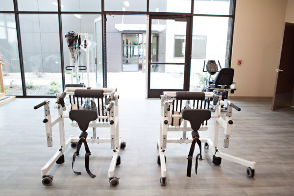 Therapy equipment in therapy room with large windows and glass doors.